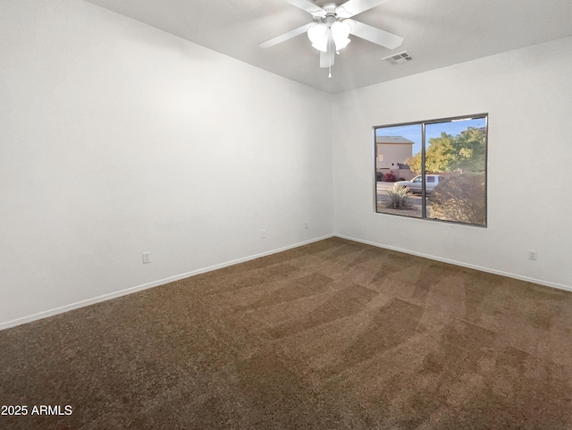 empty room featuring dark colored carpet and ceiling fan