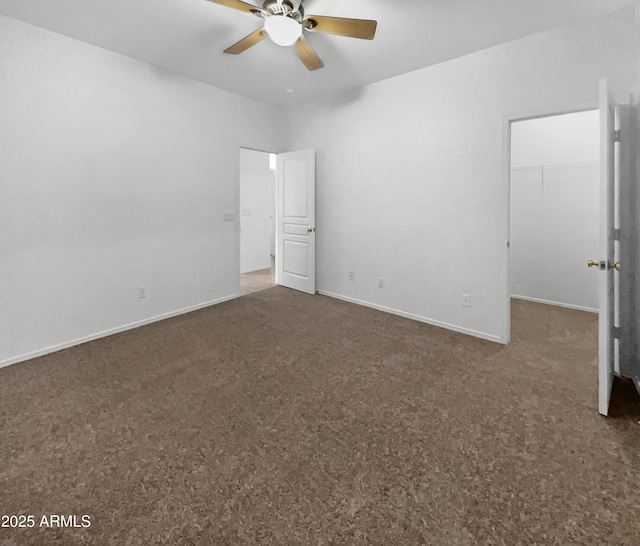 unfurnished bedroom featuring a closet, a spacious closet, and ceiling fan