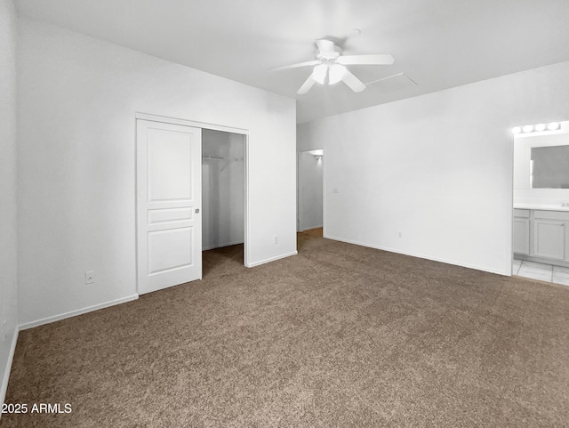 unfurnished bedroom featuring ceiling fan, light carpet, connected bathroom, and a closet