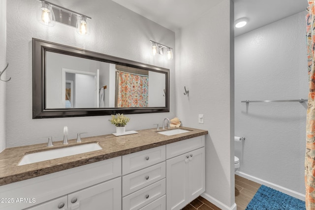 bathroom featuring vanity, curtained shower, and toilet