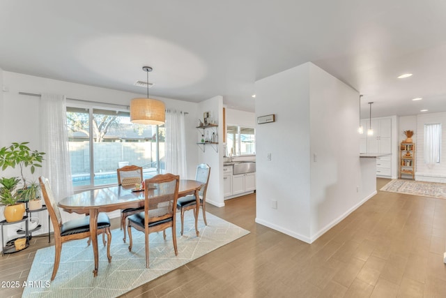 dining room featuring sink and light hardwood / wood-style flooring