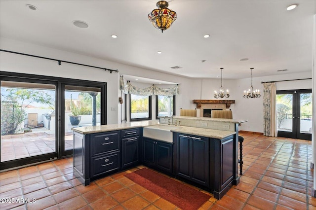 kitchen featuring visible vents, recessed lighting, french doors, dark cabinetry, and a sink