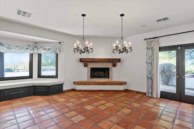 unfurnished living room featuring visible vents, a fireplace with raised hearth, french doors, and baseboards