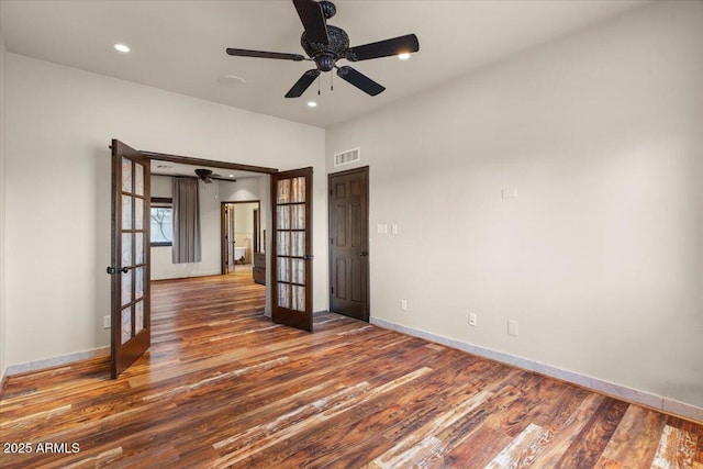 unfurnished room featuring wood finished floors, visible vents, baseboards, recessed lighting, and french doors