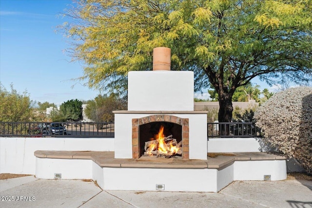 view of patio featuring a warm lit fireplace