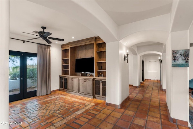 hall with arched walkways, recessed lighting, french doors, and baseboards