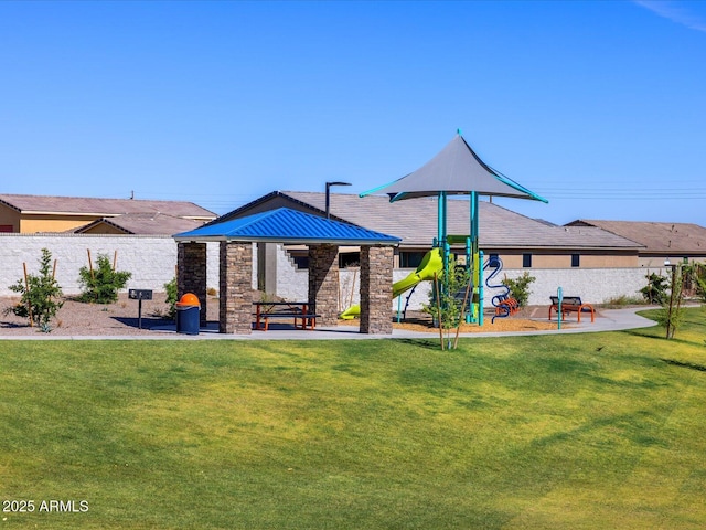 back of property featuring stone siding, playground community, and a yard