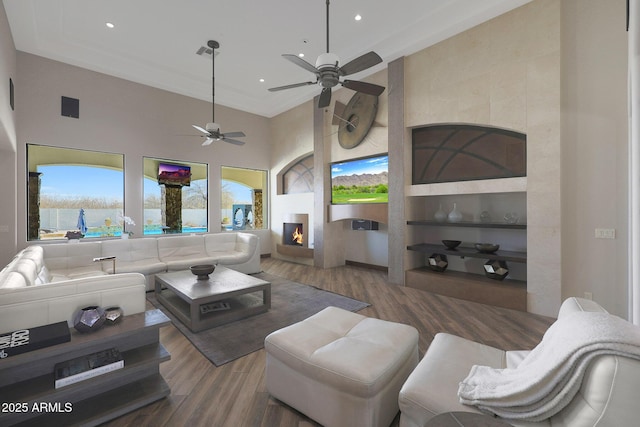 living room with plenty of natural light, a towering ceiling, and dark hardwood / wood-style flooring