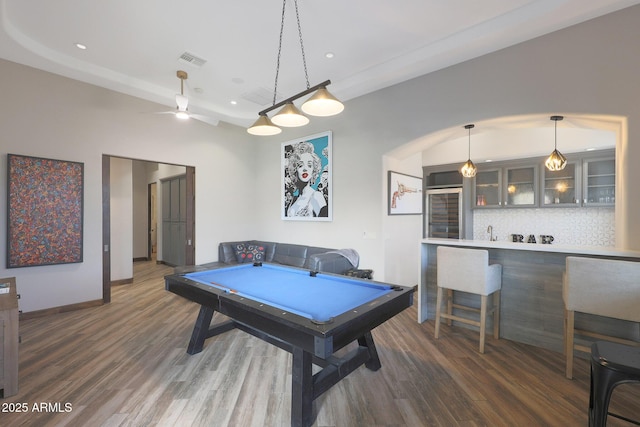 game room with dark wood-type flooring and indoor bar