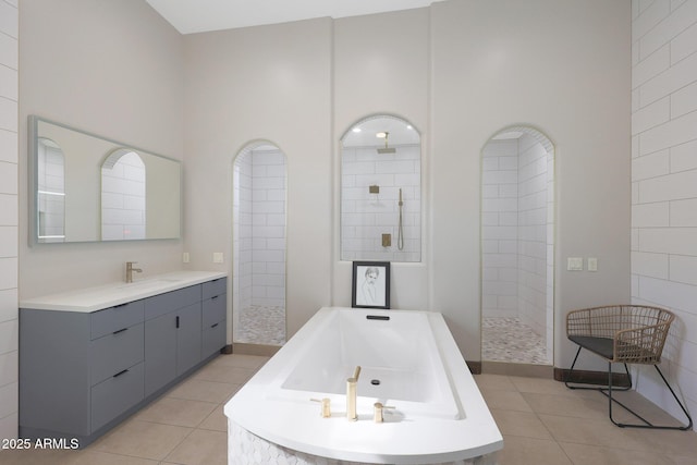 bathroom featuring shower with separate bathtub, tile patterned floors, and vanity