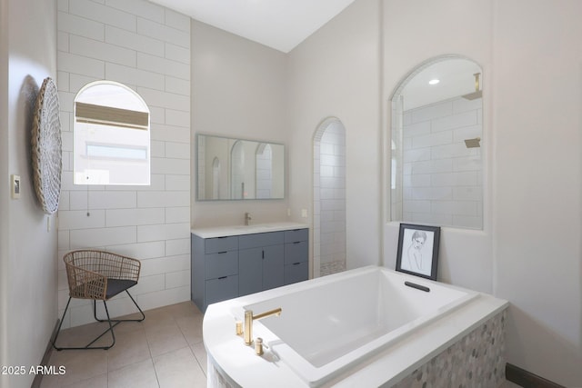 bathroom featuring tile patterned floors, plus walk in shower, and vanity