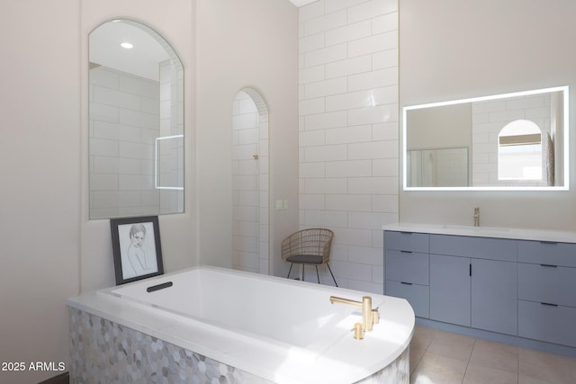 bathroom with vanity, tiled tub, and tile patterned floors