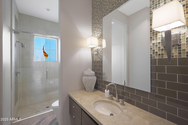 bathroom featuring vanity, toilet, and a shower with shower door