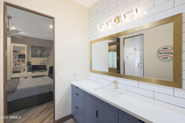 bathroom featuring vanity, hardwood / wood-style flooring, tasteful backsplash, and ceiling fan