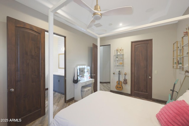 bedroom with hardwood / wood-style flooring, ensuite bath, and ceiling fan