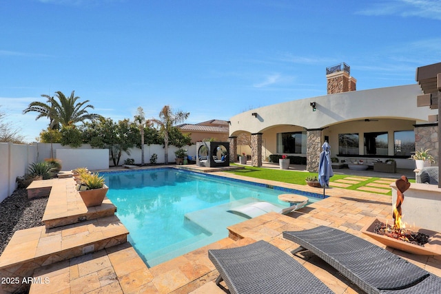 view of pool with a patio and a fire pit