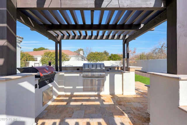 view of patio featuring an outdoor kitchen, a grill, and a pergola