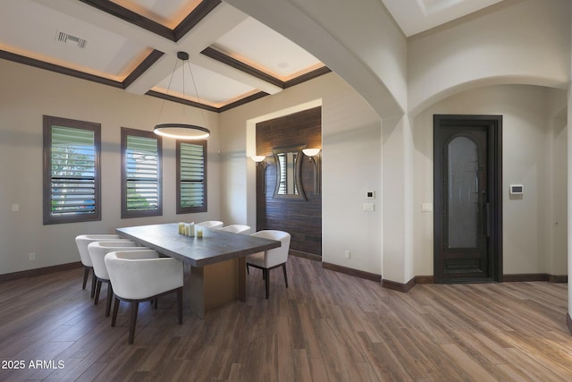 dining space with beamed ceiling, coffered ceiling, and dark hardwood / wood-style flooring