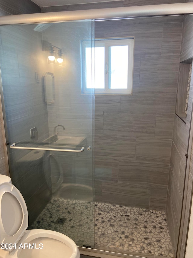 bathroom with toilet and an enclosed shower