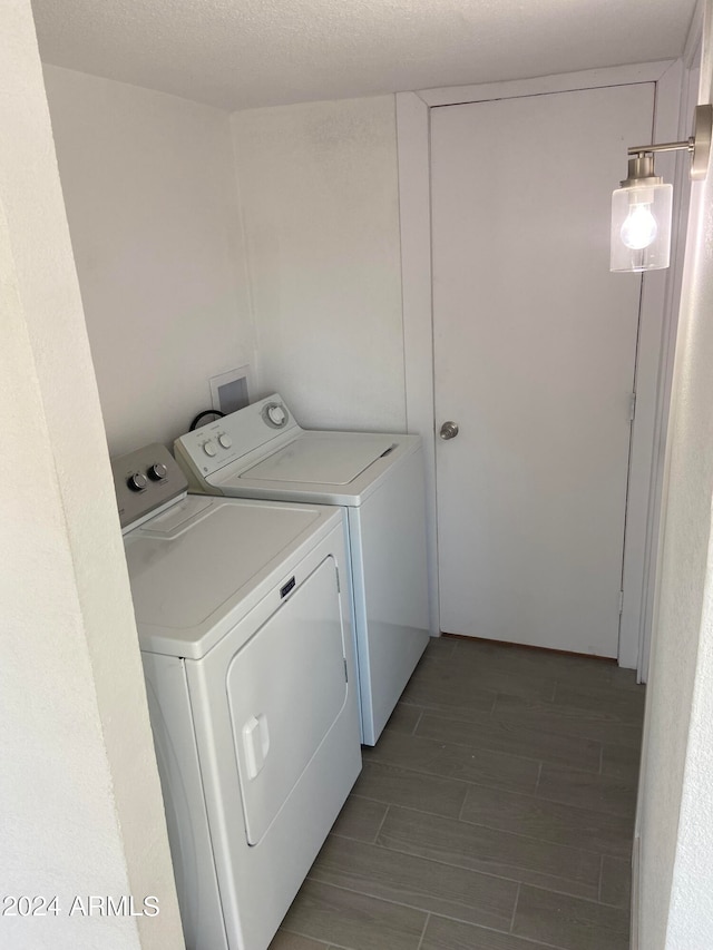 washroom with washer and clothes dryer and a textured ceiling