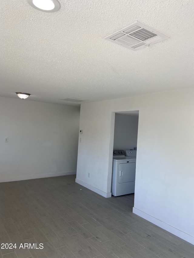 unfurnished room featuring separate washer and dryer and a textured ceiling