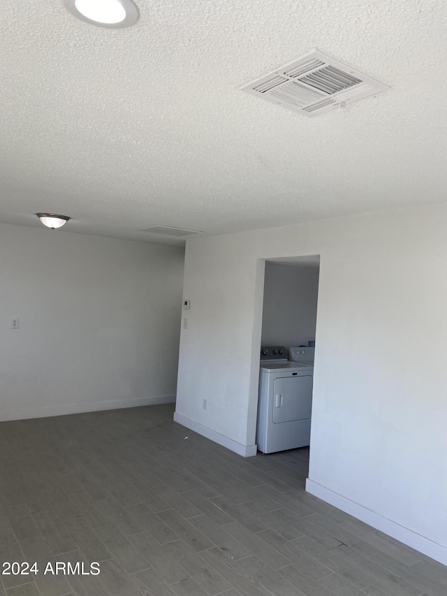 spare room featuring baseboards, visible vents, wood finished floors, and washing machine and clothes dryer