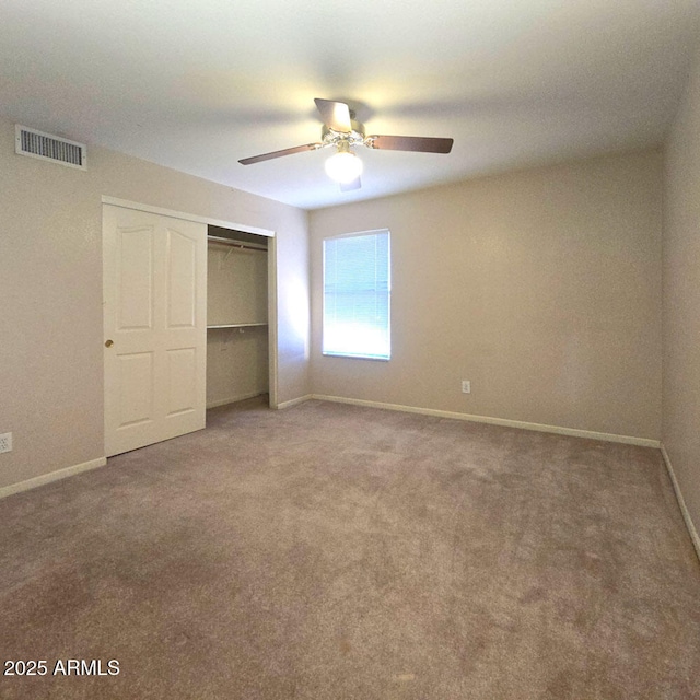 unfurnished bedroom featuring ceiling fan, a closet, and carpet