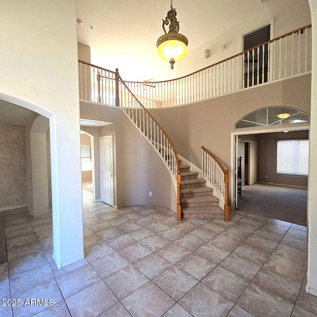 stairs featuring a towering ceiling