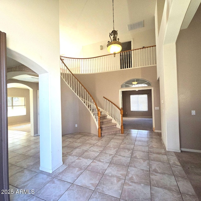 tiled entrance foyer with a towering ceiling