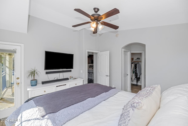 bedroom with a closet, a walk in closet, lofted ceiling, and ceiling fan