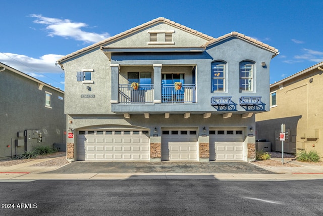 view of front of home with a balcony and a garage