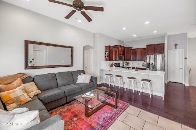 living room featuring light wood-type flooring, ceiling fan, and sink