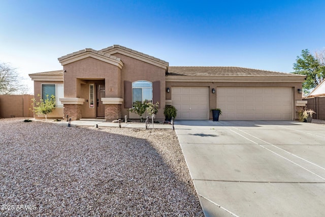 view of front facade featuring stucco siding, concrete driveway, an attached garage, and fence