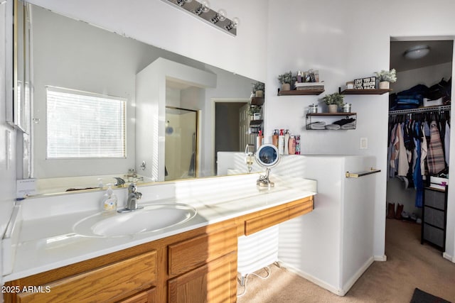 full bathroom with vanity, a shower stall, and a spacious closet