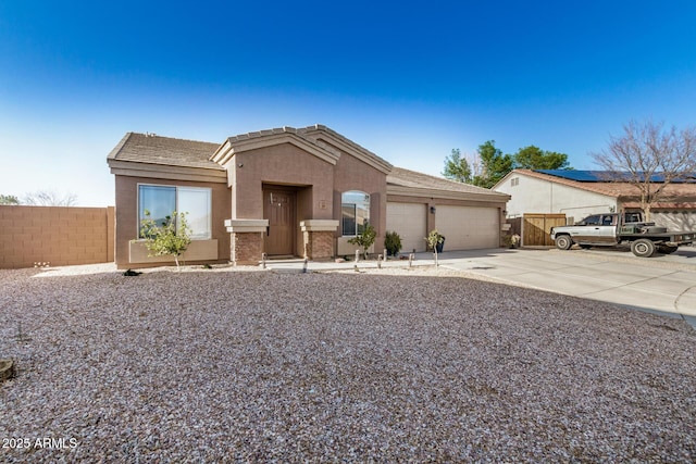 view of front of property with concrete driveway, an attached garage, fence, and stucco siding