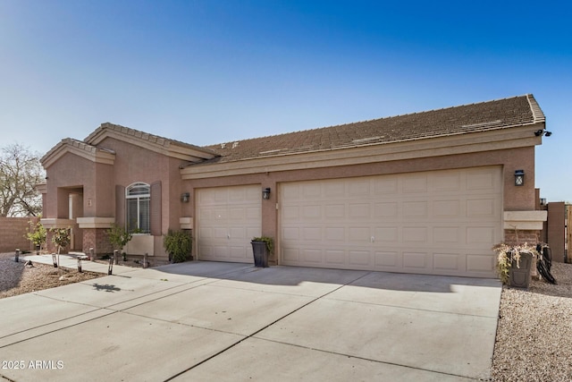 view of front of home with stucco siding, an attached garage, and driveway