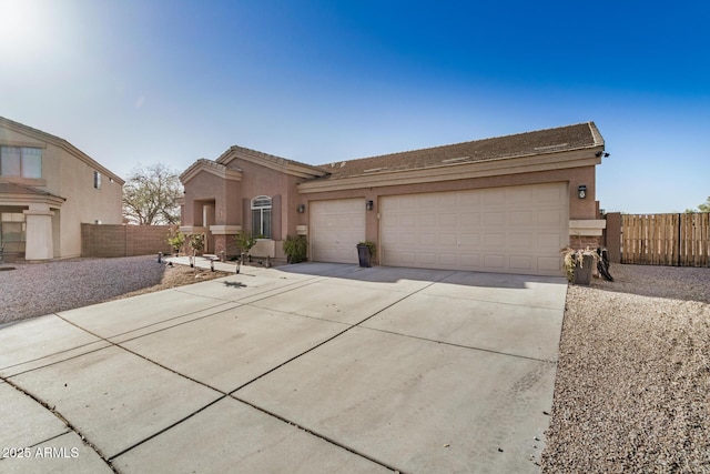 view of front facade with stucco siding, a garage, driveway, and fence