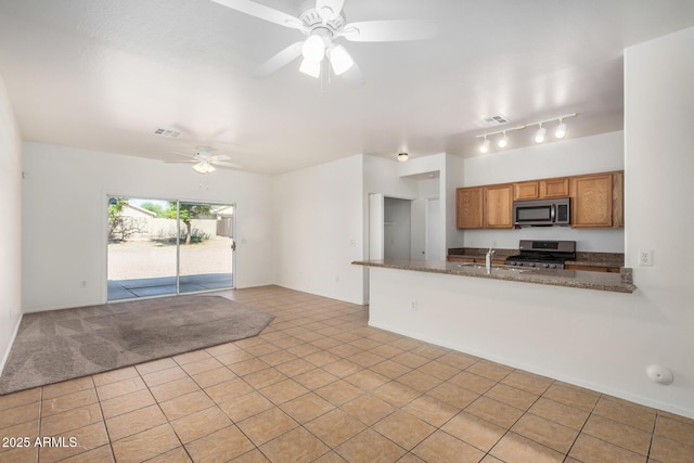 1501 S 122nd Ave, Avondale, AZ 85323 - kitchen with appliances with stainless steel finishes, brown cabinets, a ceiling fan, light tile patterned floors, and a peninsula