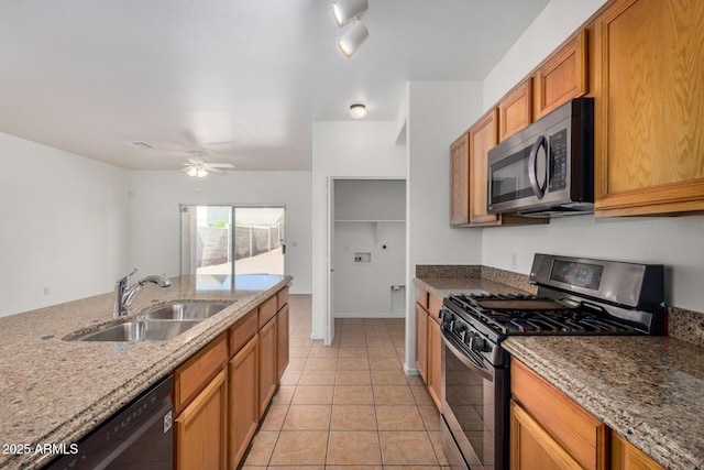 1501 S 122nd Ave, Avondale, AZ 85323 - kitchen with stainless steel microwave, gas range, dishwasher, dark stone counters, and light tile patterned floors