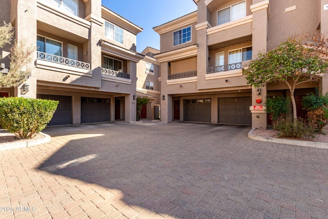 view of property with a garage and decorative driveway