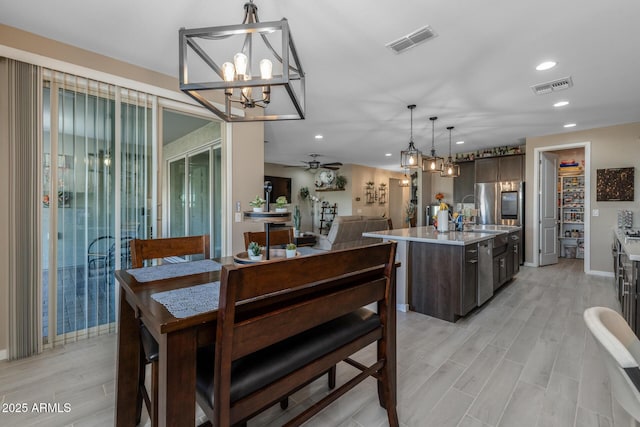 dining room featuring ceiling fan, sink, and light hardwood / wood-style floors