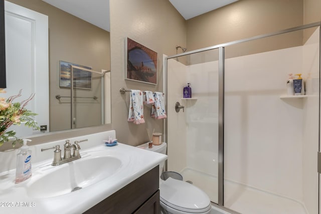 bathroom with vanity, a shower with shower door, and toilet