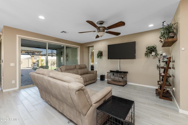 living room with light hardwood / wood-style flooring and ceiling fan