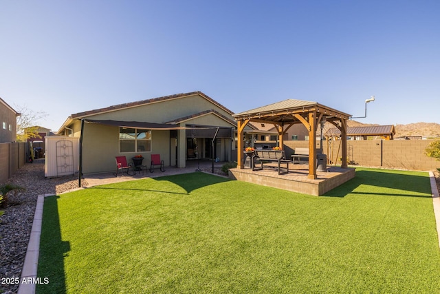 back of property featuring a yard, a gazebo, and a patio