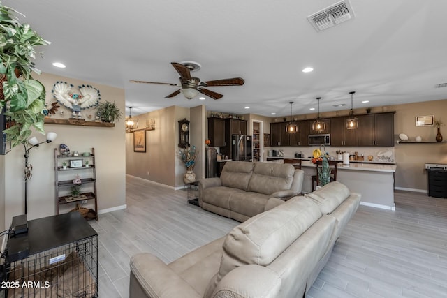 living room featuring light hardwood / wood-style floors and ceiling fan