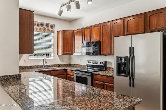 4380 E Renee Dr, Phoenix, AZ 85050 - kitchen featuring appliances with stainless steel finishes, a sink, a peninsula, dark stone counters, and track lighting