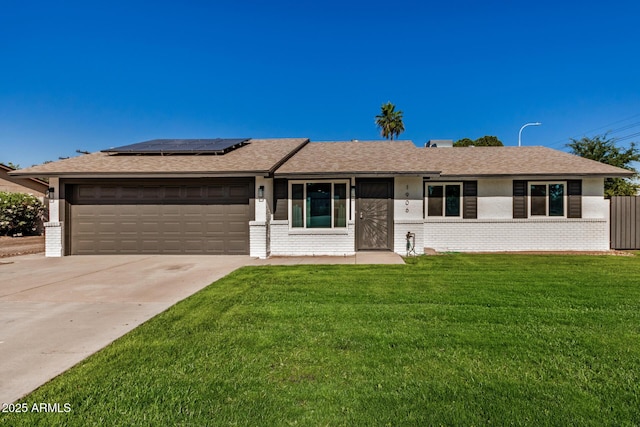 1906 N Evergreen St, Chandler, AZ 85225 - single story home with brick siding, an attached garage, roof mounted solar panels, concrete driveway, and a front yard