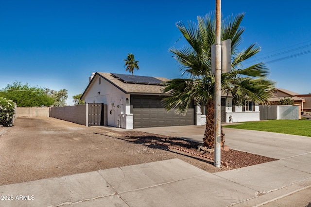 1906 N Evergreen St, Chandler, AZ 85225 - view of front of house with an attached garage, driveway, a gate, and roof mounted solar panels