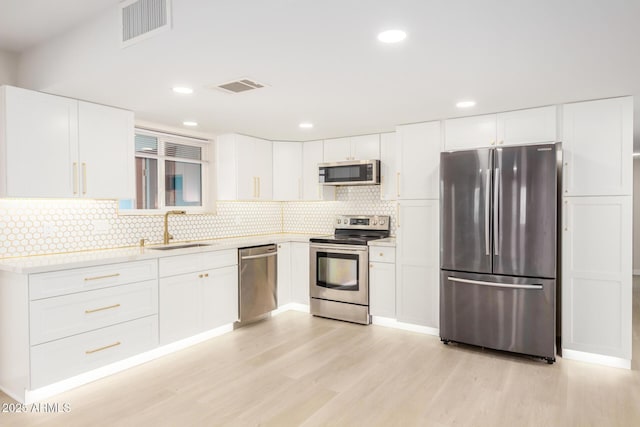 1906 N Evergreen St, Chandler, AZ 85225 - kitchen featuring stainless steel appliances, a sink, light wood-style flooring, decorative backsplash, and light countertops