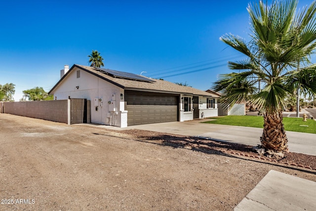 1906 N Evergreen St, Chandler, AZ 85225 - single story home featuring an attached garage, driveway, roof mounted solar panels, a chimney, and a gate